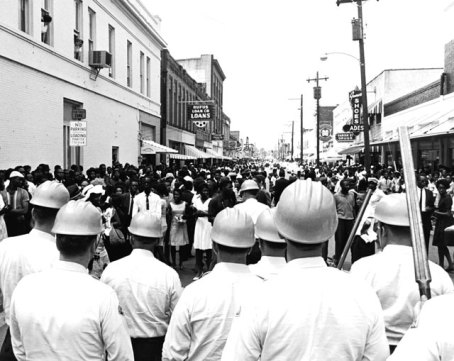 White policemen wear hardhats and carry double-barrelled shotguns as they block mourners demonstrating at the funeral of slain civil rights activist Medgar Evers, Jackson, June 15, 1963. (Express Newspapers/Getty Images)