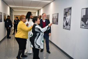 Reena Evers-Everette (forefront) reflects on a photo of herself as a child with her family that hangs in the walls of the Bedford Building at Medgar Evers College. She is joined by President Dr. Patricia Ramsey (in gold), Ilyasah Shabazz (daughter of Malcolm X) and CUNY Chancellor Felix Matos Rodriguez. (Nick Masuda/Office of Communications)