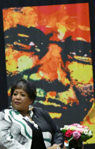 Against a backdrop of her father, Medgar Wiley Evers, the incomparable Reena Evers-Everette speaks to the sold-out "Daughters of the Legacy" event in April that kicked off the celebration of Medgar's centennial celebration. (Nick Masuda/Office of Communications)