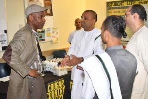 Dr. Waleek Boone, who runs the Transition Academy at Medgar Evers College, visits with World Food Movement leadership as they prepared to launch the weekly feeding of students on campus. (Nick Masuda/Office of Communications)