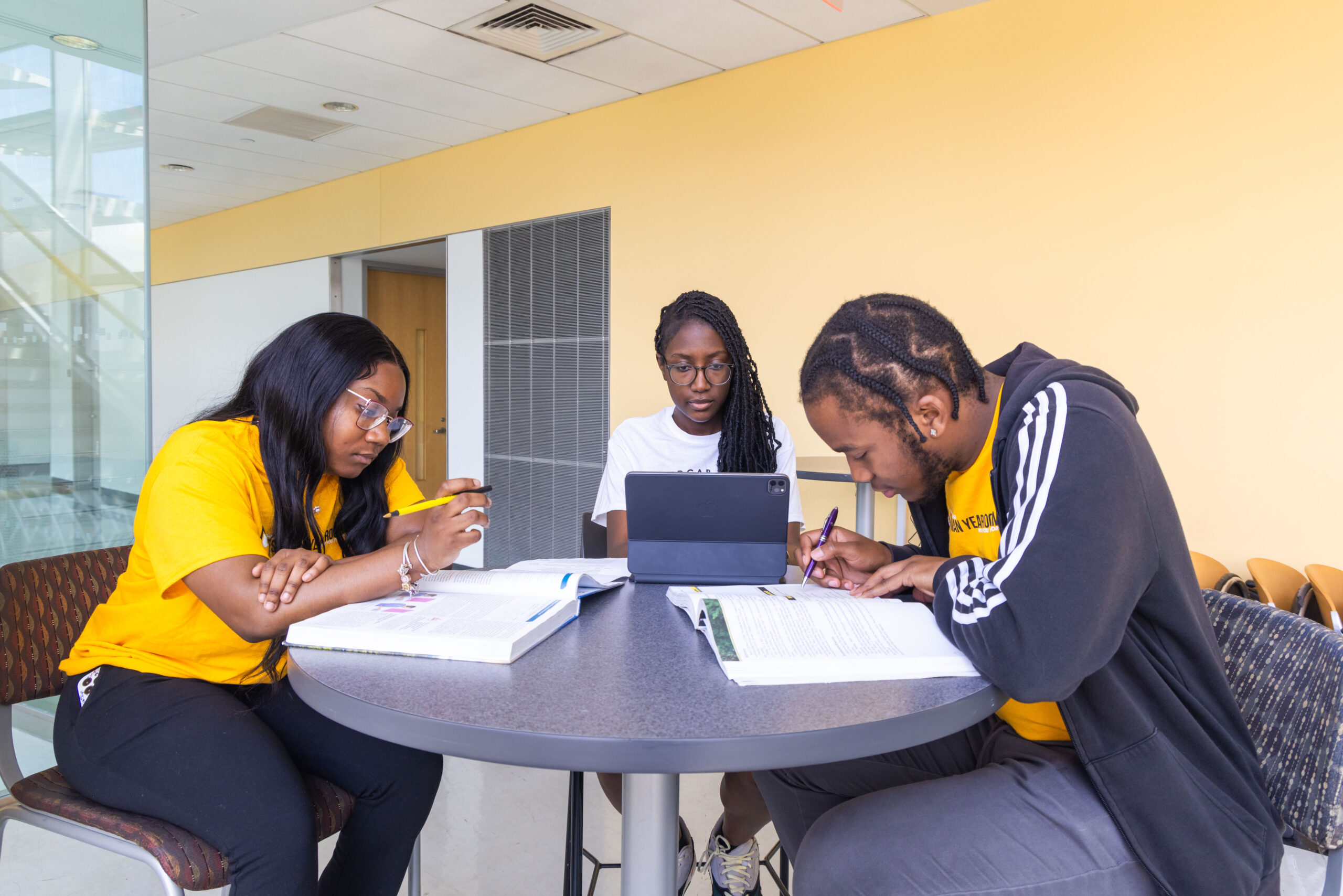 three students studying at a table