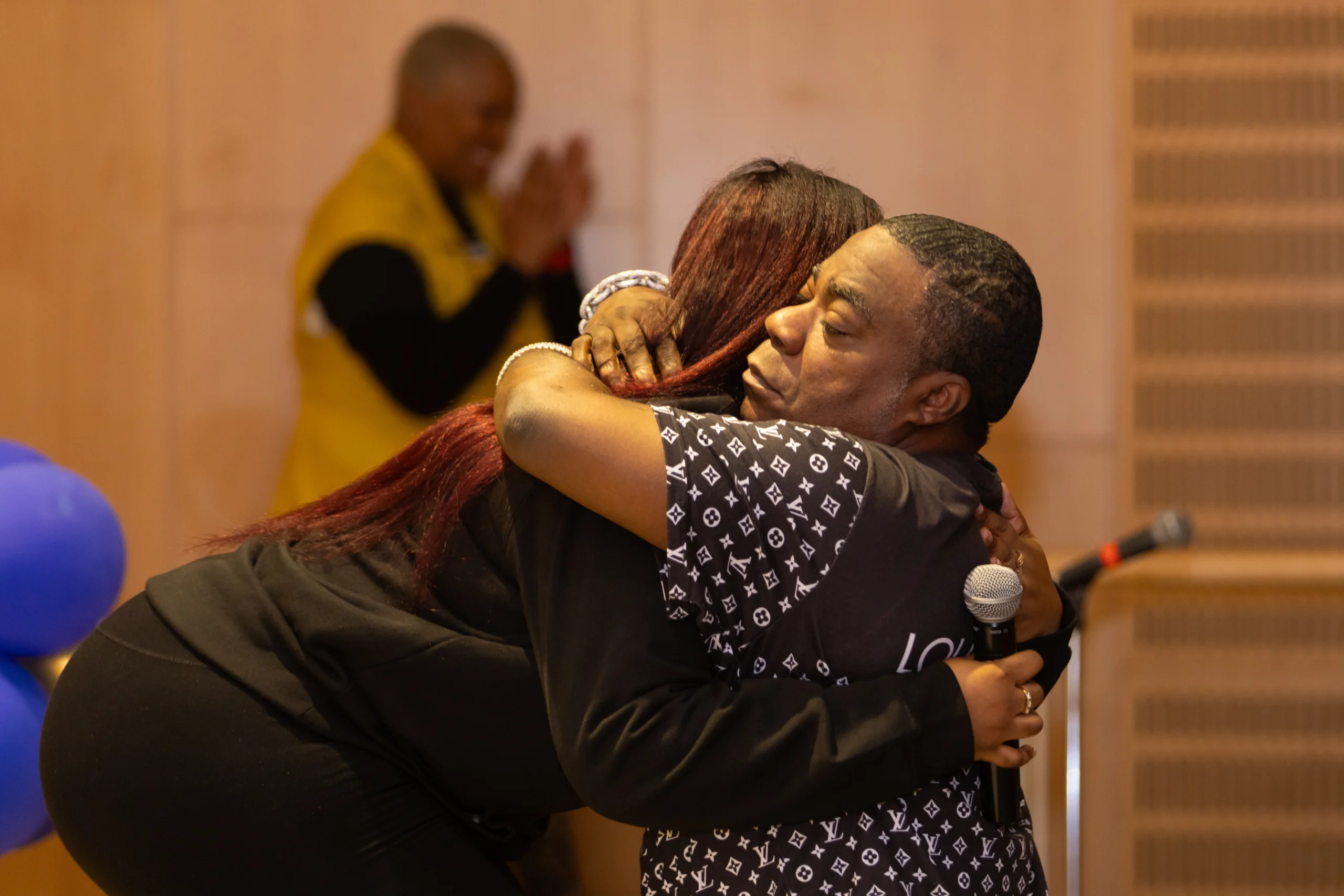 Guest speaker Tracy Morgan embraces Jade Ashton, a single mother of five, as she receives the Resilience & Persistence Award for her determination and perseverance during the completion ceremony.